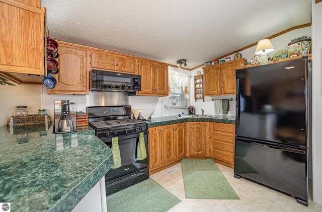 kitchen with a sink, a textured ceiling, and black appliances