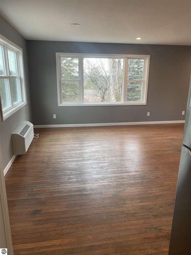 7228B S M-88, Bellaire, MI 49615 - empty room with dark wood finished floors, baseboards, a wall mounted AC, and recessed lighting
