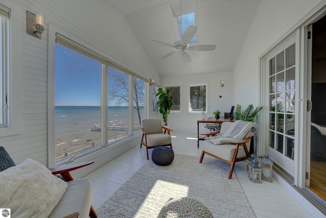 sunroom / solarium with vaulted ceiling, wood finished floors, and a water view
