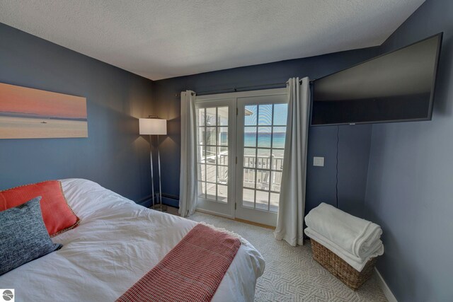 carpeted bedroom featuring baseboards, access to outside, and a textured ceiling