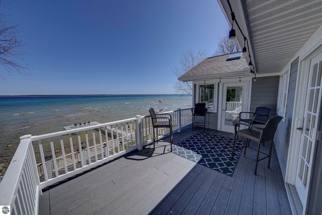 deck with a view of the beach and a water view