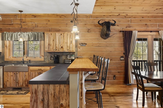 kitchen featuring a kitchen bar, plenty of natural light, tasteful backsplash, and light wood-type flooring