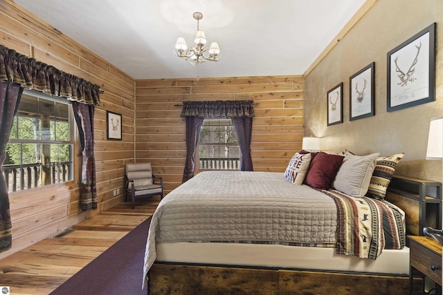 bedroom featuring a chandelier, wood finished floors, and wood walls