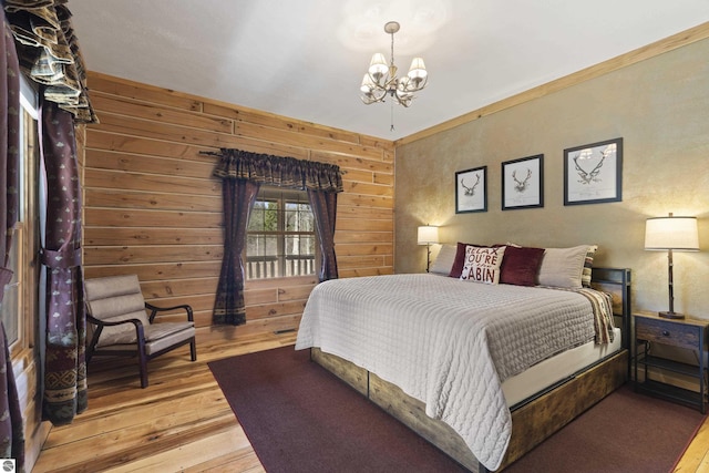 bedroom with wood-type flooring, wood walls, and a notable chandelier