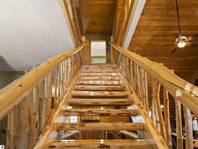 stairway with a high ceiling, wood ceiling, and ceiling fan