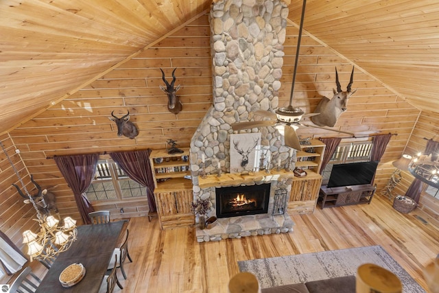 living room with hardwood / wood-style flooring, wooden ceiling, lofted ceiling, and a stone fireplace