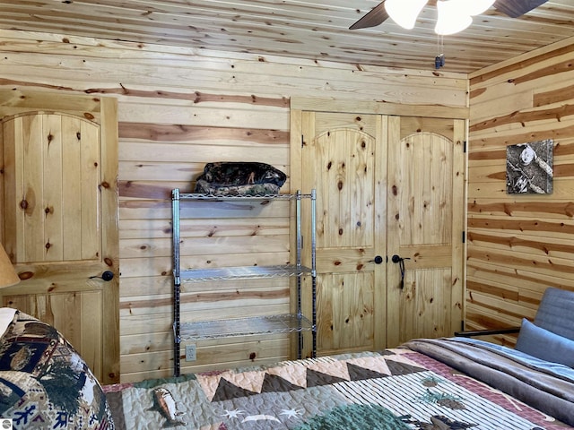 bedroom with wooden ceiling, a ceiling fan, and wooden walls
