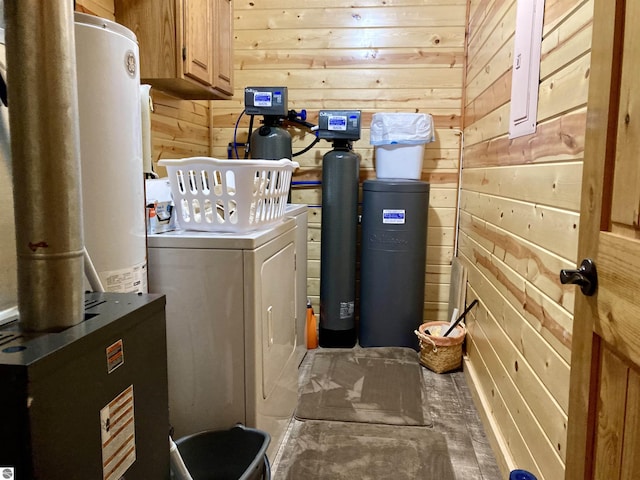 washroom with cabinet space, wooden walls, and independent washer and dryer
