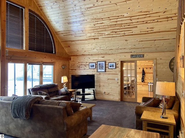 living room featuring lofted ceiling, dark colored carpet, and wooden walls