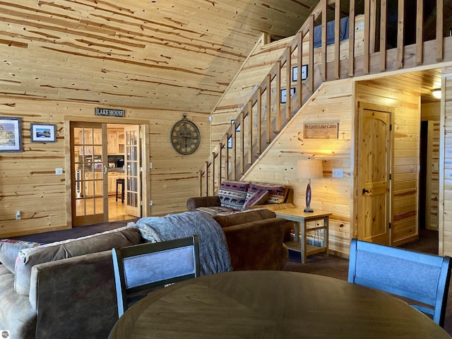 living area with wooden walls, wooden ceiling, and high vaulted ceiling