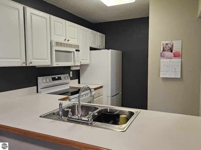 100 Fourth Ave Unit E-3, Tawas City, MI 48763 - kitchen featuring light countertops, a sink, white appliances, a textured ceiling, and white cabinetry