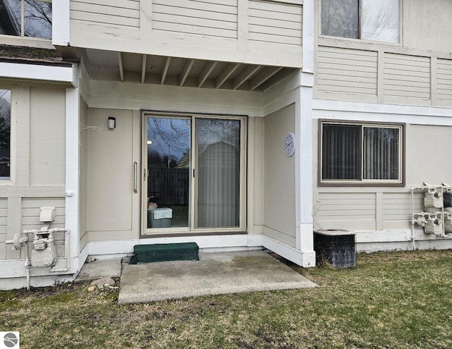 100 Fourth Ave Unit E-3, Tawas City, MI 48763 - entrance to property featuring central AC and a lawn