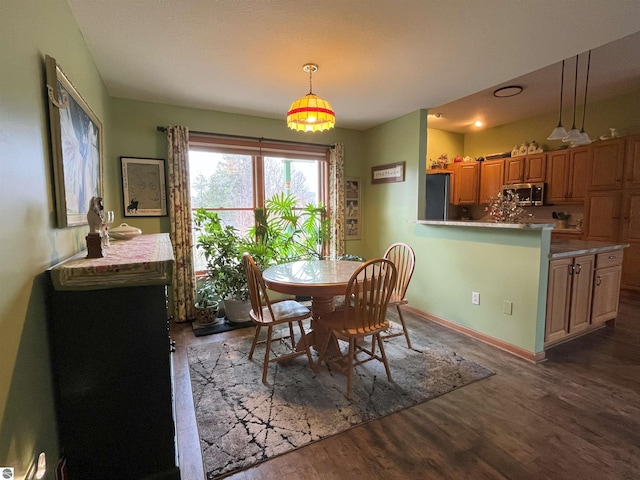 dining room featuring wood finished floors and baseboards