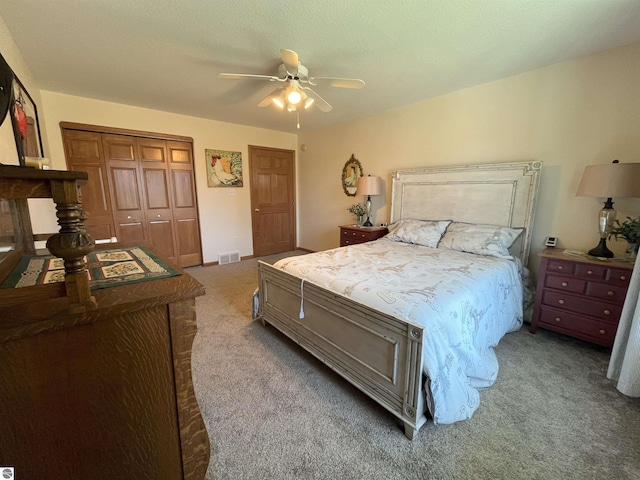 bedroom with visible vents, carpet, a closet, and ceiling fan