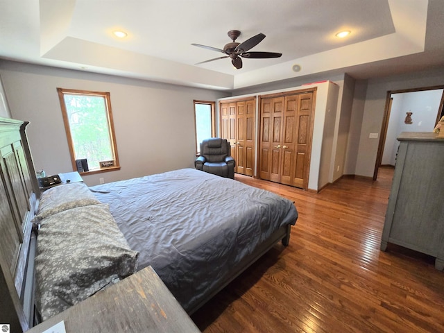 bedroom featuring recessed lighting, wood finished floors, and a raised ceiling