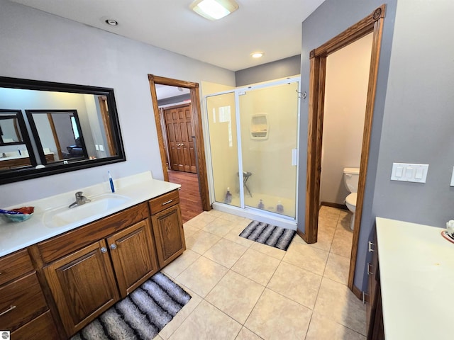 full bathroom featuring vanity, tile patterned flooring, a shower stall, and toilet