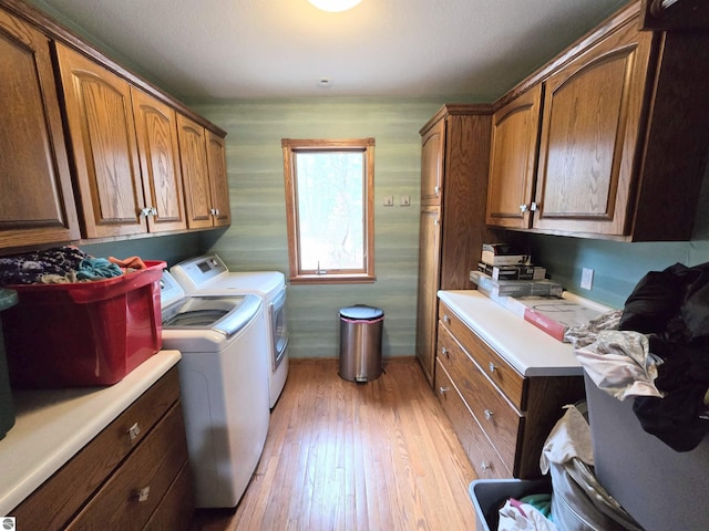 laundry room featuring cabinet space, light wood-type flooring, and washer and dryer