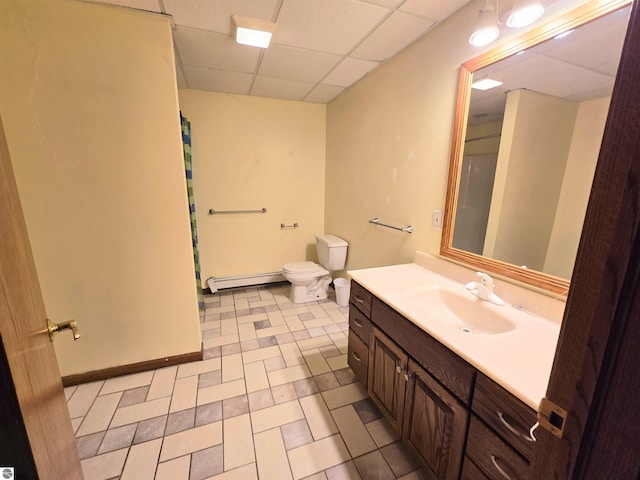 bathroom featuring a baseboard radiator, vanity, toilet, a shower with shower curtain, and a paneled ceiling
