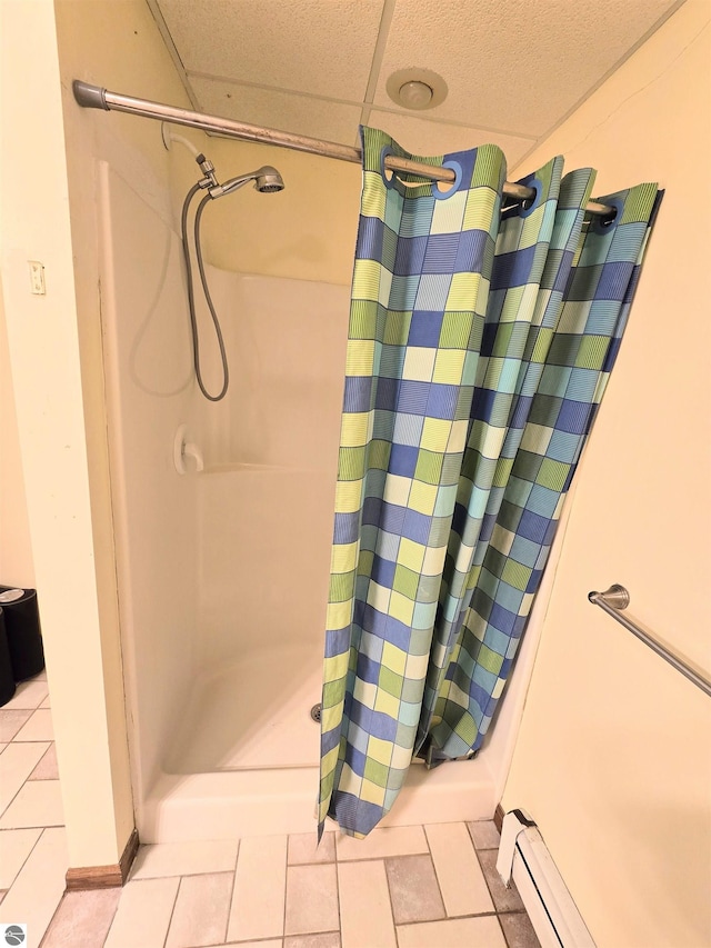 full bath featuring tile patterned floors, a shower with shower curtain, and a baseboard radiator