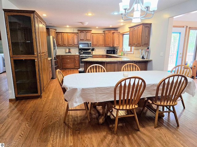 dining room featuring recessed lighting, light wood-style flooring, and a notable chandelier