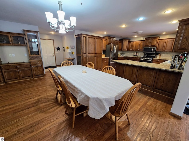 dining room with an inviting chandelier, recessed lighting, and dark wood-style flooring