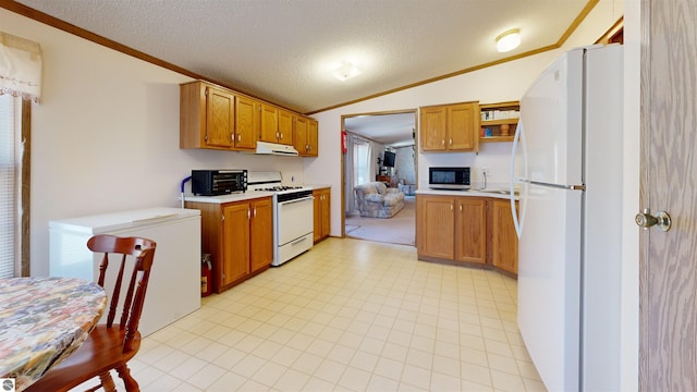 kitchen featuring vaulted ceiling, ornamental molding, white appliances, and light countertops
