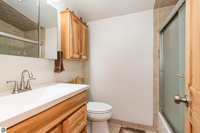 3901 W Thendara Dr, Gladwin, MI 48624 - full bathroom with tile patterned floors, enclosed tub / shower combo, visible vents, toilet, and vanity