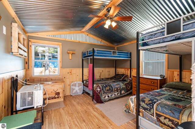 3901 W Thendara Dr, Gladwin, MI 48624 - bedroom featuring lofted ceiling, a wainscoted wall, wooden walls, and wood finished floors