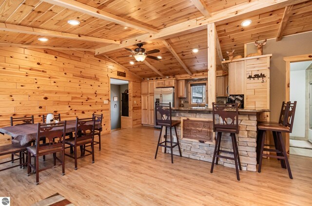 3901 W Thendara Dr, Gladwin, MI 48624 - dining space featuring lofted ceiling with beams, light wood finished floors, wood walls, ceiling fan, and wood ceiling