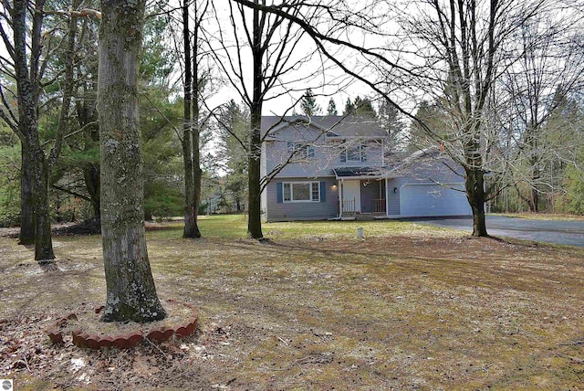 traditional home with a garage and aphalt driveway