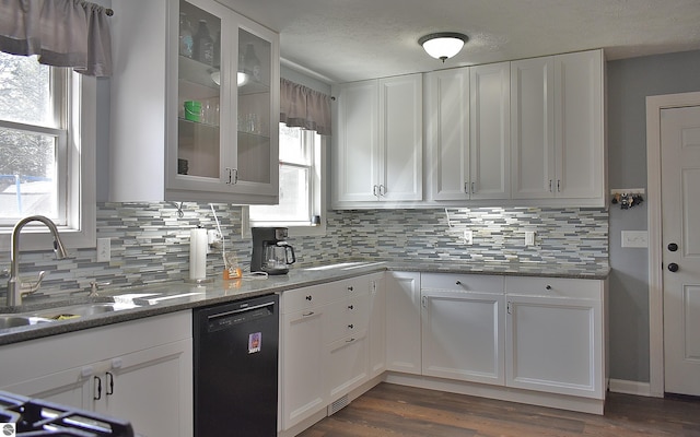 kitchen featuring a wealth of natural light, tasteful backsplash, black dishwasher, and white cabinetry