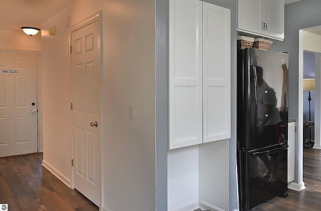 kitchen featuring white cabinets, baseboards, freestanding refrigerator, and dark wood-style flooring