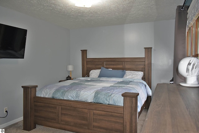 bedroom featuring baseboards, carpet, and a textured ceiling