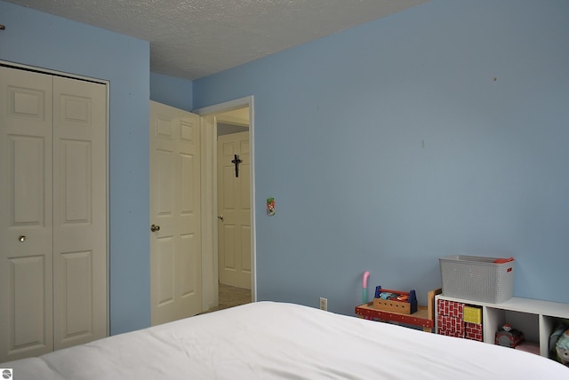 bedroom featuring a textured ceiling and a closet
