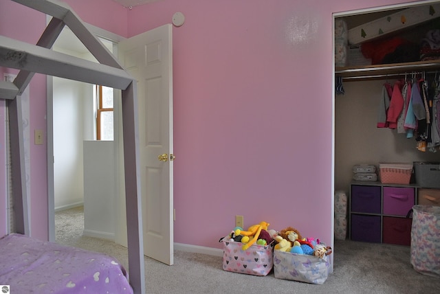 carpeted bedroom with a closet and baseboards
