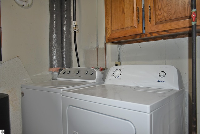 laundry room featuring separate washer and dryer and cabinet space