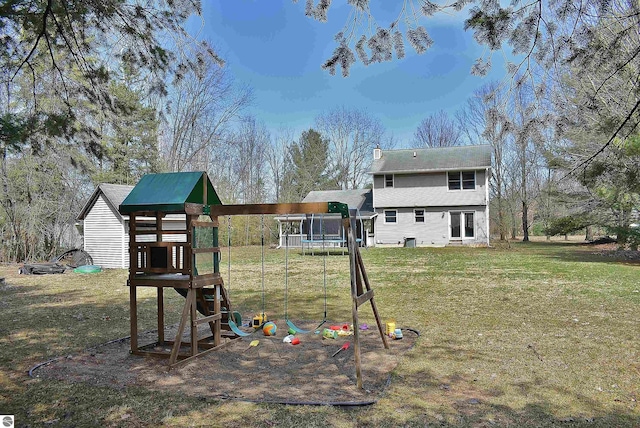 exterior space with a lawn, a trampoline, a chimney, and a playground