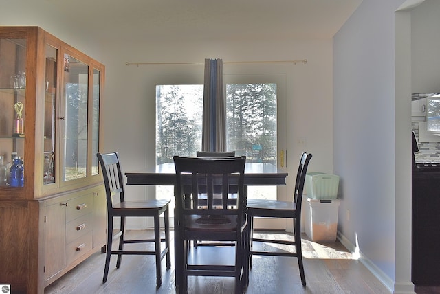 dining room with light wood-type flooring and baseboards