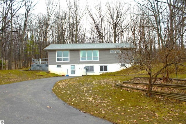 view of front of property with a wooden deck and a front yard