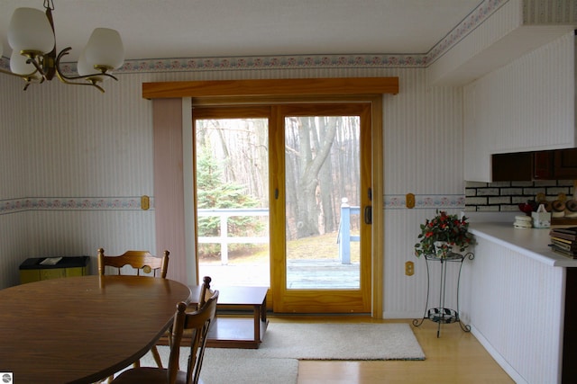 dining room with wallpapered walls and light wood-style flooring