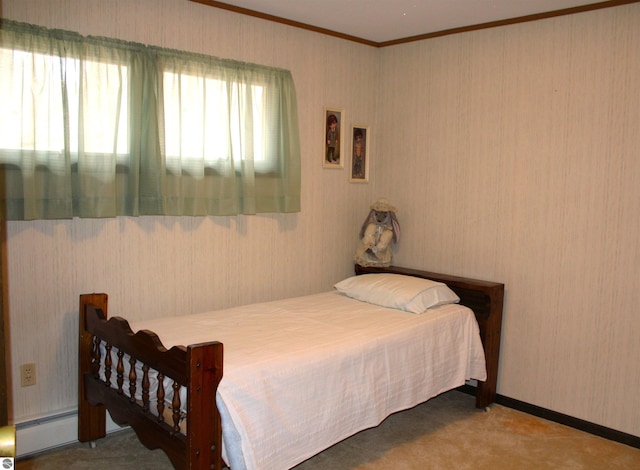 bedroom with a baseboard heating unit, crown molding, and carpet flooring