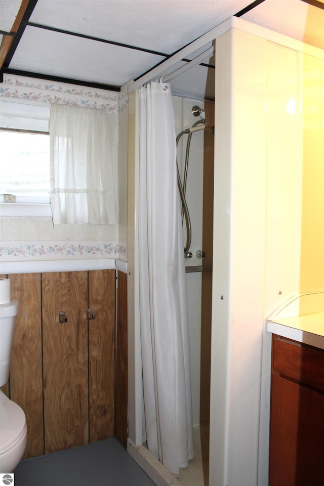 bathroom featuring curtained shower and toilet