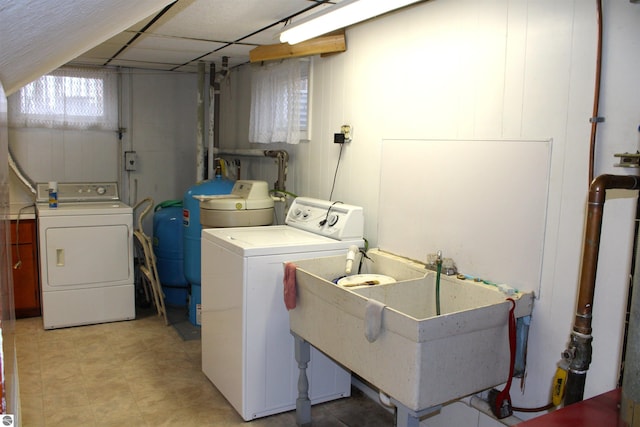 laundry area with washing machine and clothes dryer, a sink, and laundry area