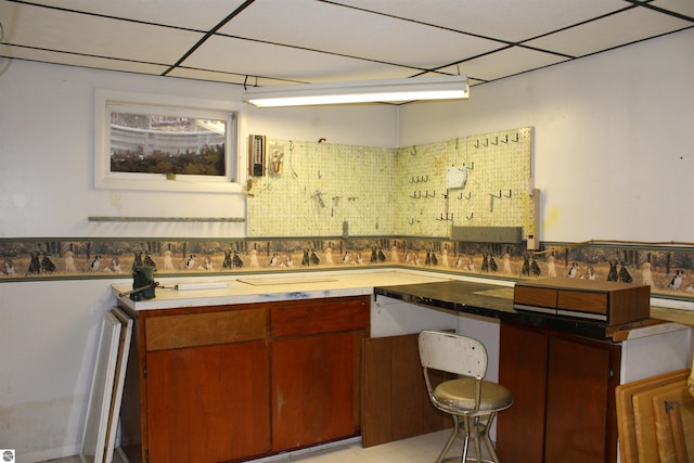 kitchen with a kitchen bar and a paneled ceiling