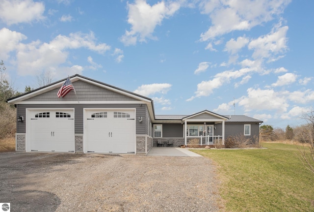 craftsman house with stone siding, driveway, a front yard, and a garage
