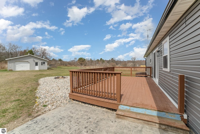 wooden deck with a garage, a lawn, and an outbuilding
