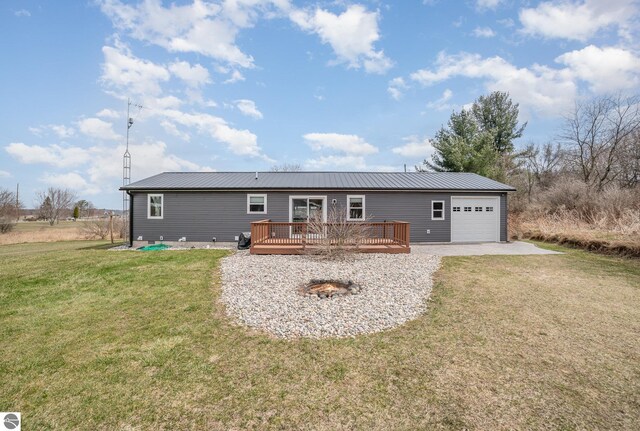 exterior space with a wooden deck, an attached garage, a front yard, and metal roof