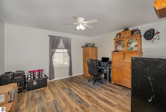 office space with baseboards, wood finished floors, and ceiling fan