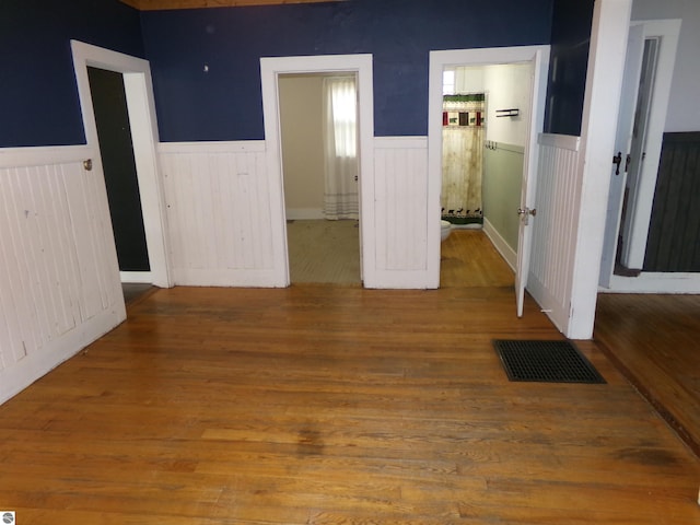 116 N Main St, Saint Louis, MI 48880 - interior space with a wainscoted wall, wood finished floors, visible vents, and ensuite bathroom