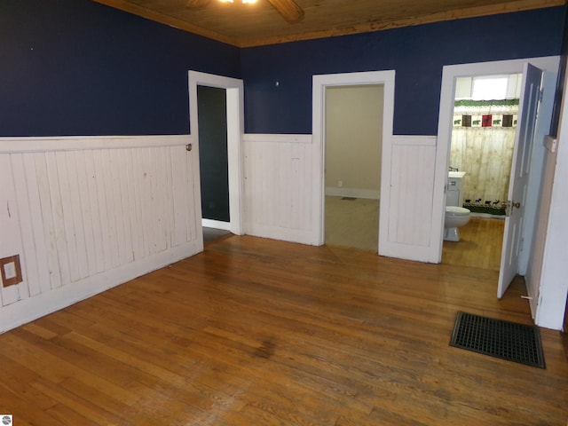 116 N Main St, Saint Louis, MI 48880 - unfurnished room with wainscoting, wood finished floors, visible vents, and ceiling fan